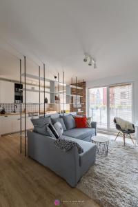 salon z szarą kanapą i kuchnią w obiekcie Chmielna Park w Gdańsku