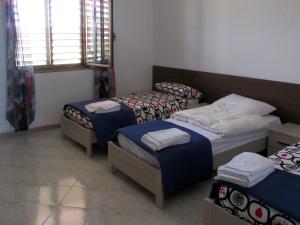a room with three beds and a window at Ostello Bella Calabria in Torre Ritani