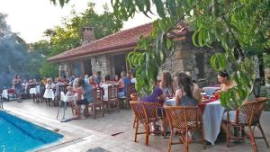 a group of people sitting at tables outside a restaurant at Doga Apartments in Kayakoy