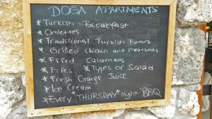 a chalkboard sign on the wall of a restaurant at Doga Apartments in Kayakoy