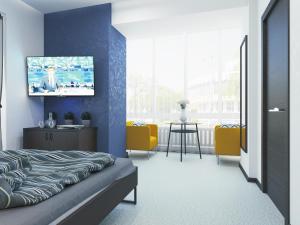 ニジネカムスクにあるГостиница 116の青い壁にテレビが備わるベッドルーム1室