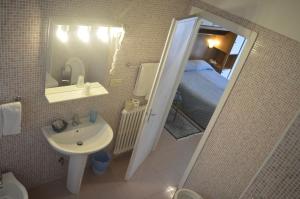 ein kleines Badezimmer mit Waschbecken und Bett in der Unterkunft Hotel Svizzera in Arma di Taggia