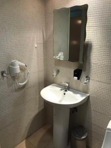 a bathroom with a sink and a mirror at Captain Yiannis Studios & Apartments in Kos