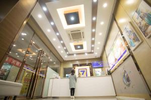 a woman standing at a counter in a building at 7Days Inn Huizhou West Lake in Huizhou