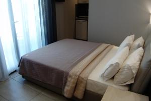 a bedroom with a bed with pillows and a window at Il Mondo Residence in Stavros