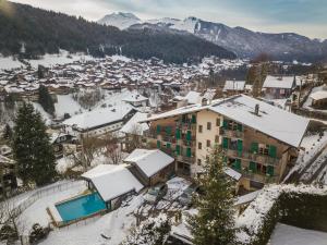 a town covered in snow with mountains in the background at L'Hermine Blanche in Morzine