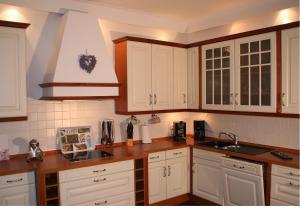 a kitchen with white cabinets and wooden counter tops at Ferienhaus Landhaus Uttum in Krummhörn