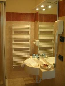 ein Bad mit einem Waschbecken und einem Spiegel in der Unterkunft Hotel Susa & Stazione in Susa