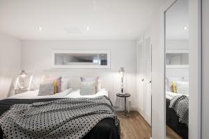 a white bedroom with a bed and a mirror at Hotel Fabian in Helsinki