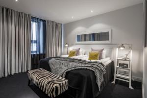 a hotel room with a large bed with yellow pillows at Hotel Fabian in Helsinki