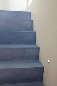 a set of blue stairs next to a white wall at La Casetta 19 in Polignano a Mare