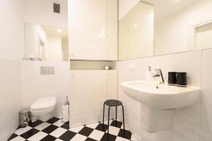 a white bathroom with a sink and a toilet at Crystal Suites Chez Helena in Kraków +46 photos