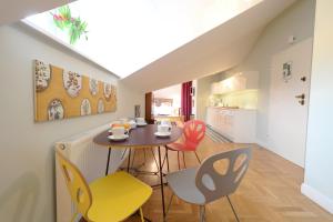 a kitchen and dining room with a table and chairs at Crystal Suites Chez Helena in Kraków