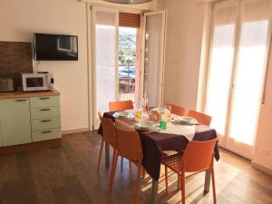 une salle à manger avec une table et des chaises ainsi qu'une cuisine dans l'établissement Cabà Holiday Bardolino D'Annunzio, à Bardolino