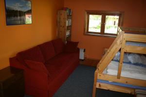 ein Wohnzimmer mit einem Sofa und einem Etagenbett in der Unterkunft Ahornfarm Håkannäs in Kristinehamn