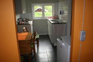 una pequeña cocina con mesa y fregadero en Ahornfarm Håkannäs en Kristinehamn