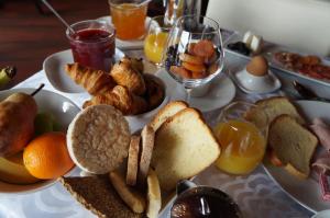 a table with a plate of bread and other breakfast foods at Hôtel L'Albatros in Saint-Trojan-les-Bains