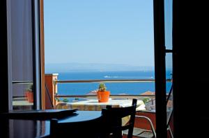 una mesa y sillas en un balcón con vistas al océano en Apartments Villa Sunrise, en Trogir