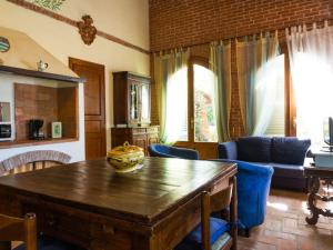 a living room with a wooden table and blue chairs at Belvilla by OYO Nice Farmhouse with Sauna Jacuzzi in Pieve a Nievole