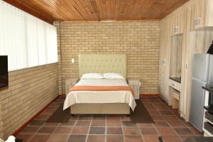 a bedroom with a bed in a brick wall at SJ's Self-Catering in Kuilsrivier