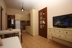 a kitchen with a flat screen tv on a dresser at Ktima Kehrioti in Panormos Skopelos