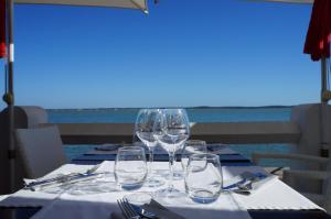 a table with wine glasses sitting on top of it at Hôtel L'Albatros in Saint-Trojan-les-Bains