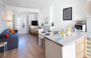 eine Küche und ein Wohnzimmer mit einem Tisch und einem Sofa in der Unterkunft Maison Bianchi - Forville in Cannes