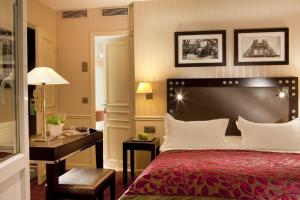 a hotel room with a bed and a desk at Hotel Duquesne Eiffel in Paris
