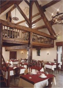 a dining room with tables and chairs in a restaurant at Auberge de la Baume in Bâlot