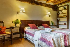 a bedroom with two beds and a chair at Hotel Akerreta in Akerreta