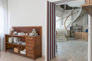 ein Flur mit einer Holzkommode und Treppe in der Unterkunft Boulevard 900 in Revello