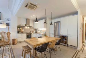 バレンシアにあるValencia Flat Rental Ensanche 1の木製テーブルと椅子付きの広いキッチン