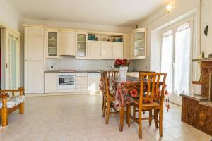 a kitchen with white cabinets and a table and chairs at Casa Berta, a due passi dal mare in Numana +24 photos