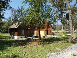 una pequeña casa en un patio con un árbol en Chalet Kampong Semawar en Kuala Kangsar