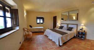 een slaapkamer met een bed, een stoel en ramen bij Cal Petit in Santa Cristina d'Aro