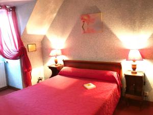 Un dormitorio con una cama roja y una bandeja. en Manoir Henri IV, en Bessines-sur-Gartempe