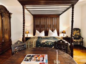 Schlafzimmer mit einem großen Bett mit einem Kopfteil aus Holz in der Unterkunft Hotel Mariahilf München in München