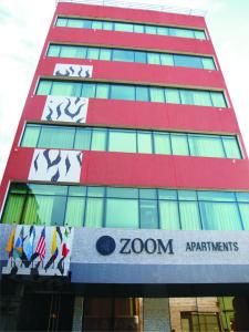 un edificio rojo alto con un letrero. en Zoom Apartments Hotel Boutique en Córdoba