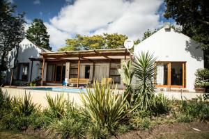 a house with a pool in front of it at Rouana Guest Farm in Stellenbosch
