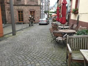 una calle adoquinada con mesas y sillas y un coche en Weingut Day, en Zell an der Mosel