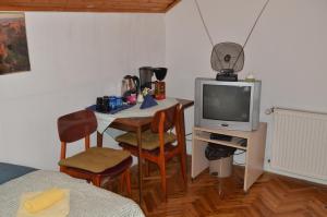 a small room with a table and a television at Rooms Mila in Rezovac