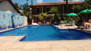 una gran piscina azul junto a una casa en San Bernardo Apart-Hotel, en Alcobaça