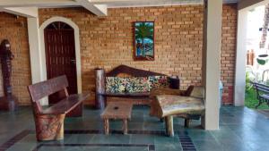 a living room with a couch and chairs and a brick wall at San Bernardo Apart-Hotel in Alcobaça