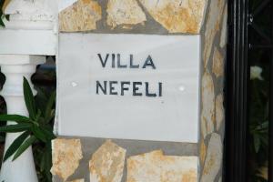 ein Schild, das die Villa netelin an einer Wand liest in der Unterkunft Villa Nefeli in Agios Georgios