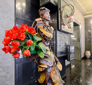 a statue of a woman holding a bouquet of red flowers at ALFAVITO Kyiv Hotel in Kyiv