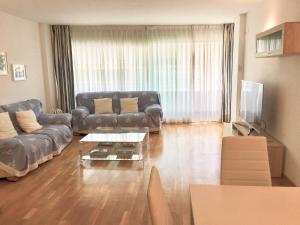 un soggiorno con divano e tavolo di Ancora Frontbeach Luxury Apartment a Tossa de Mar