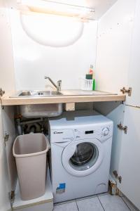 a laundry room with a sink and a washing machine at Apartma Žusterna in Koper
