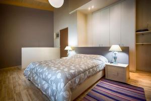 1 dormitorio con 1 cama, 2 lámparas y 1 alfombra en Archanes Residences en Archanes