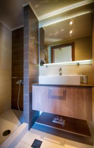 uma casa de banho com um lavatório e um espelho em Archanes Residences em Archanes
