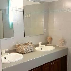 a bathroom with two sinks and a mirror at Résidence Costa d'Oru in Saint-Florent